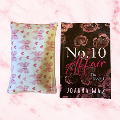 Front view of the book Number 10 Affair by Joanna Maz. It has a discreet cover with flowers. The make up bag has pink bows on the design. 